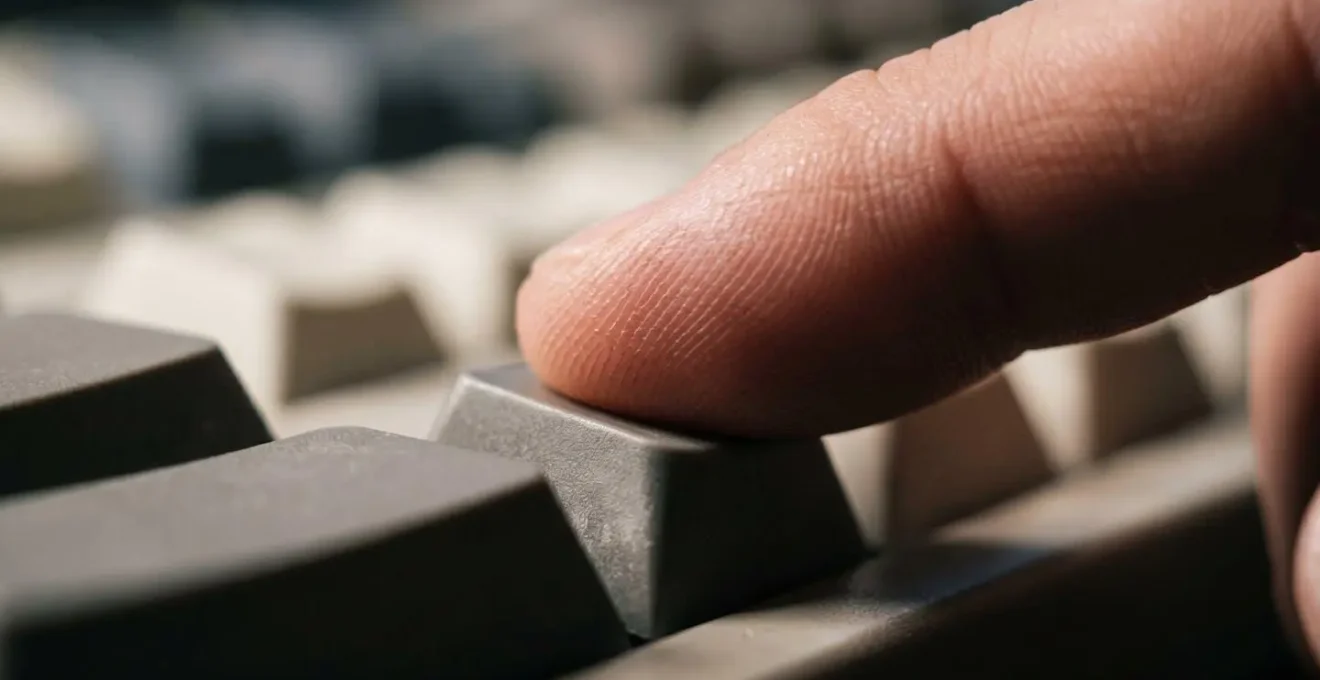 Macro close-up of human finger pressing keyboard key showing tendon strain and force distribution