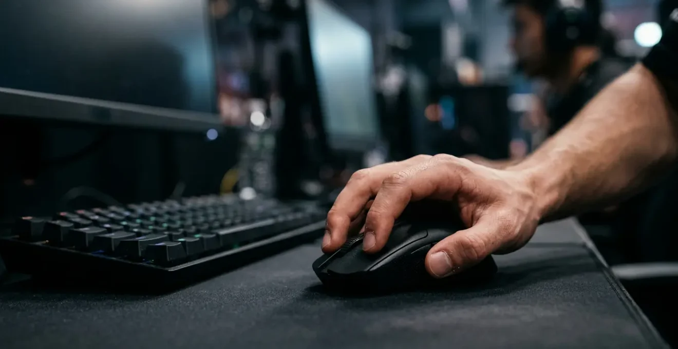 Professional esports player's hand on gaming mouse during intense competitive FPS match with motion blur emphasizing speed